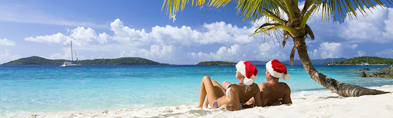 Couple with santa hats on Caribbean beach