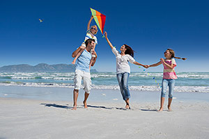 Family on Beach Flying a Kite